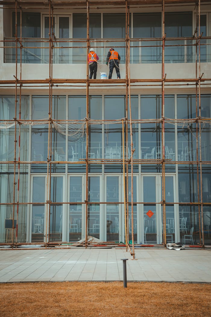 Construction workers on scaffolding repairing a building facade.